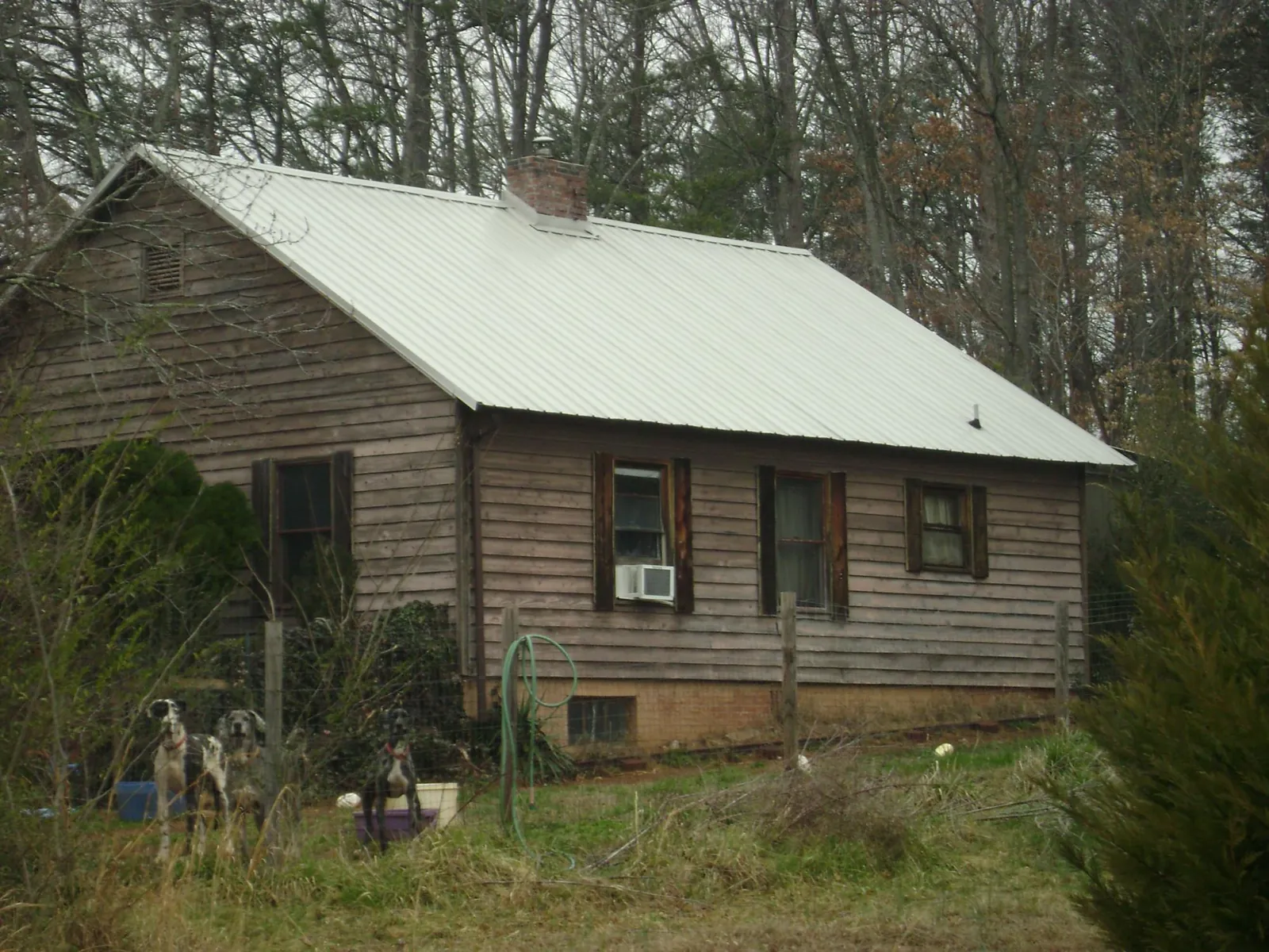 White metal roof on an old wood sided farmhouse, from a Metal Roof Installation job in Leslie